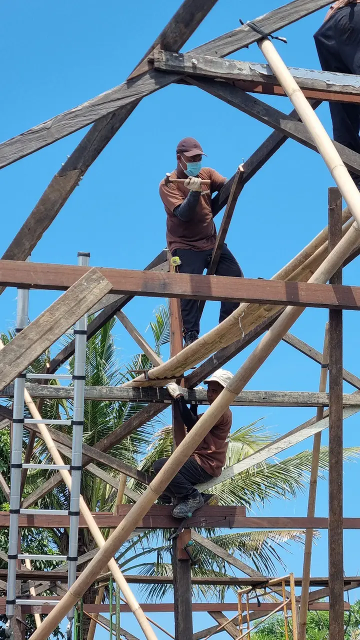 Workers dismantling an old timber structure so the wood can be reused