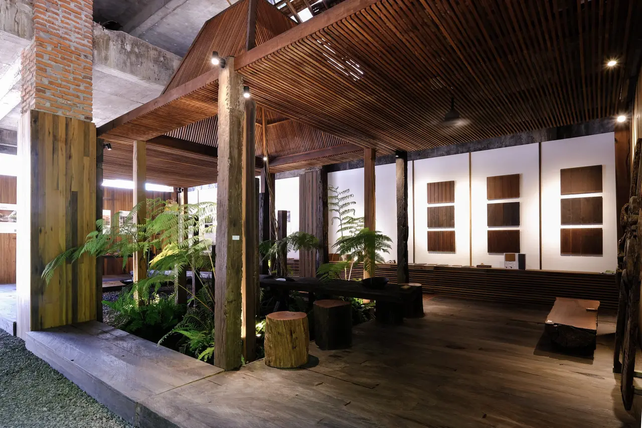 Interior with timber columns, a slatted wooden ceiling and wood panel samples on a white wall